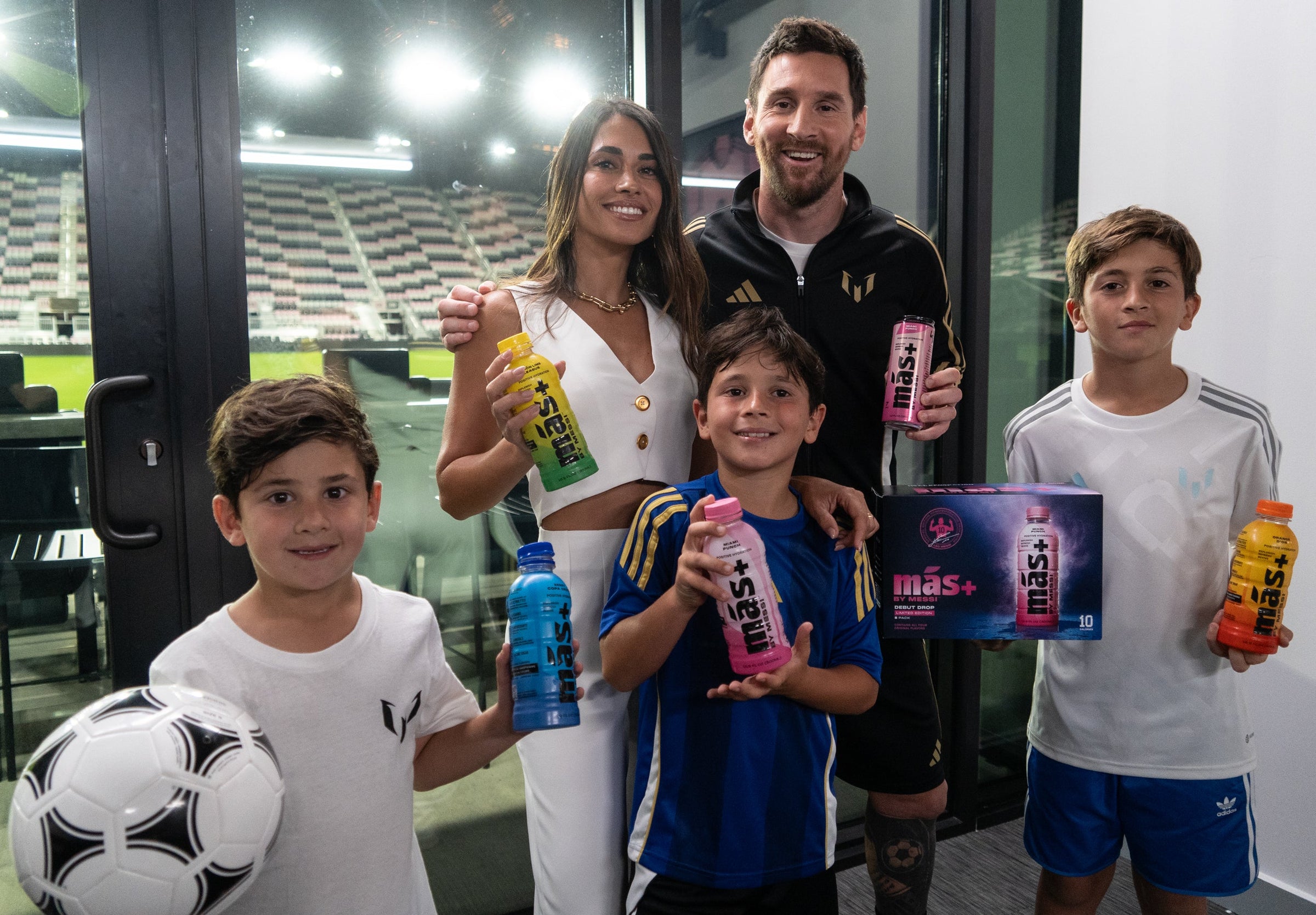Messi, su esposa Antonela y sus tres hijos, cada uno con una botella de Más+ by Messi en los sabores Orange D'Or, Miami Punch, Berry Copa Crush y Limon Lime League.